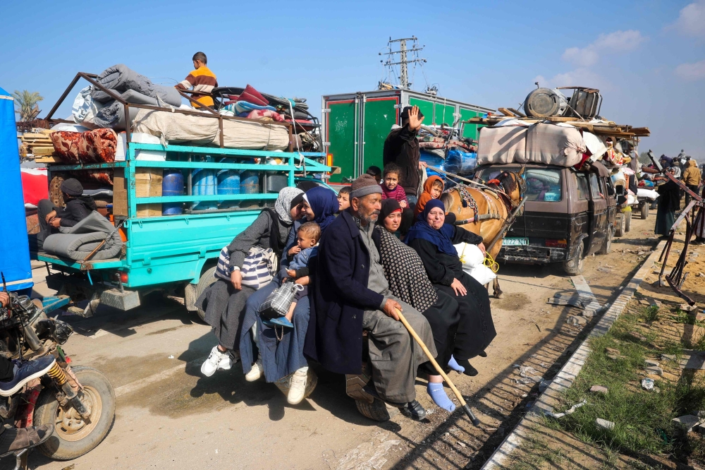 Displaced Gazans ride in the back of a horse-drawn cart as they cross the Netzarim corridor from the southern Gaza Strip. — AFP