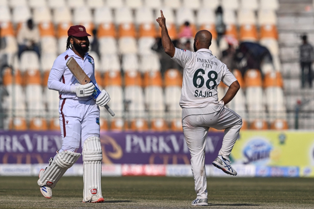 Pakistan's Sajid Khan (R) celebrates after taking the wicket of West Indies' Jomel Warrican (L) during the second day of the second Test cricket match between Pakistan and West Indies at the Multan Cricket Stadium in Multan on January 26, 2025.   (Photo by Farooq NAEEM / AFP)

