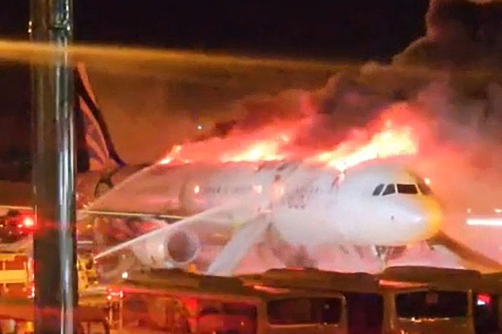 Fire authorities work to extinguish a fire that broke out on an Air Busan passenger plane at Gimhae International Airport in Busan 