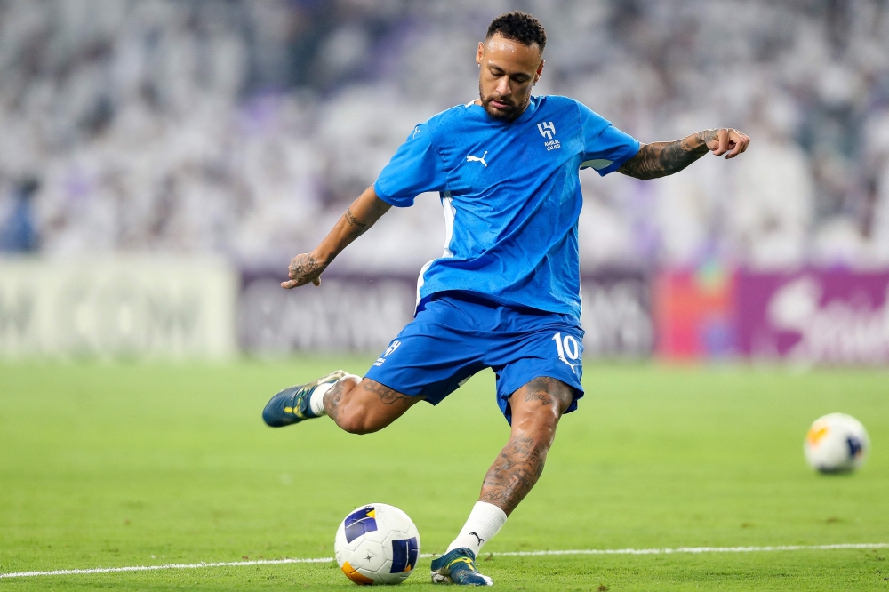 (FILES) Hilal's Brazilian forward #10 Neymar kicks the ball as he warms up ahead of the AFC Champions League group B football match between UAE's Al-Ain and Saudi's Al-Hilal at the Hazza bin Zayed Stadium in al-Ain on October 21, 2024. Brazilian star Neymar ended his injury-plagued 18-month stay in Saudi Arabia on January 27, 2025 as his club Al-Hilal said they had "agreed to terminate the player's contract by mutual consent". The 32-year-old former Barcelona and Paris Saint-Germain forward  played just seven times since joining the club in August 2023, despite a reported salary of around $104 million a year. (Photo by AFP)
