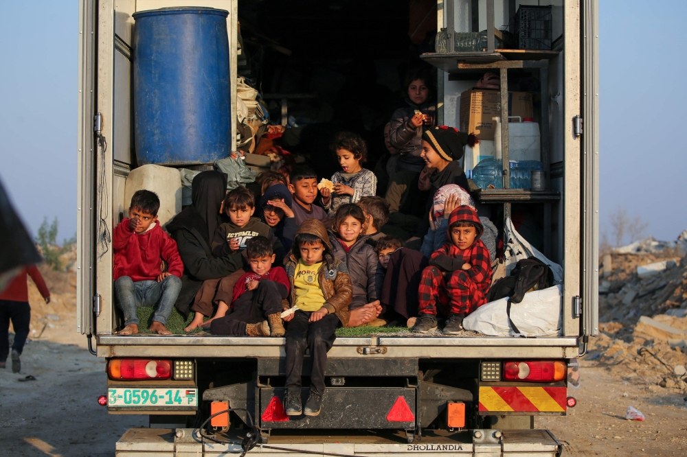 Displaced Palestinian children sit in the back of a truck making their way to the northern parts of the Gaza Strip. — AFP 