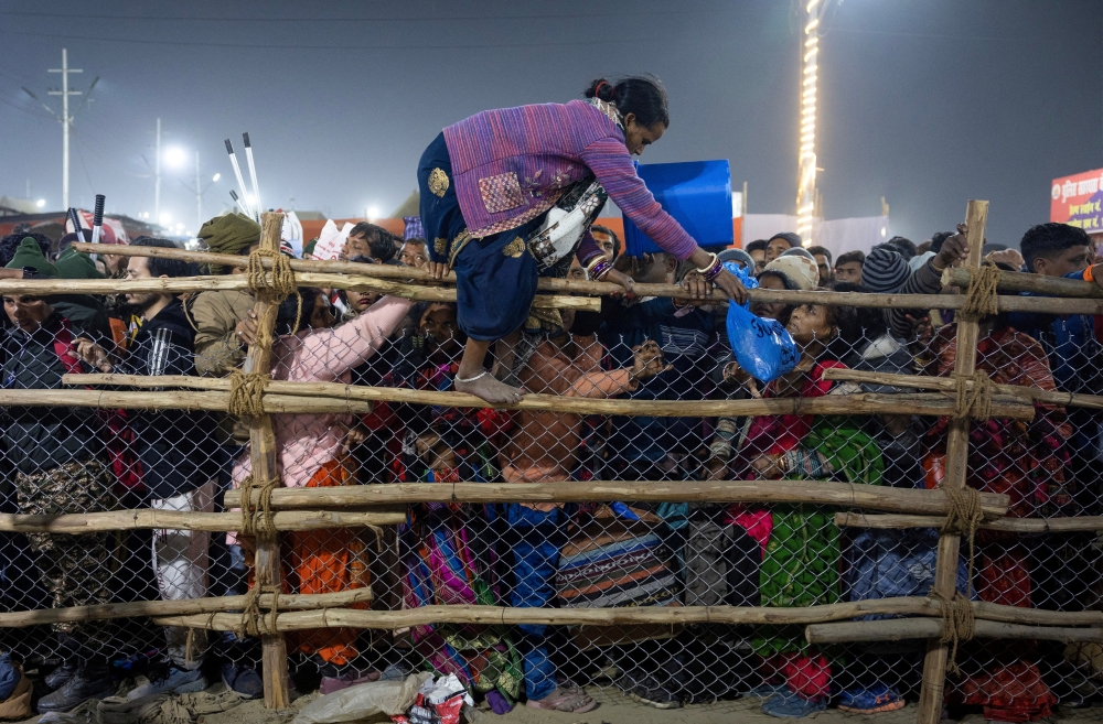 A devotee crosses over a barricade, after a deadly stampede before the second royal bath, at the Maha Kumbh Mela in Prayagraj, Uttar Pradesh on Wednesday. — Reuters