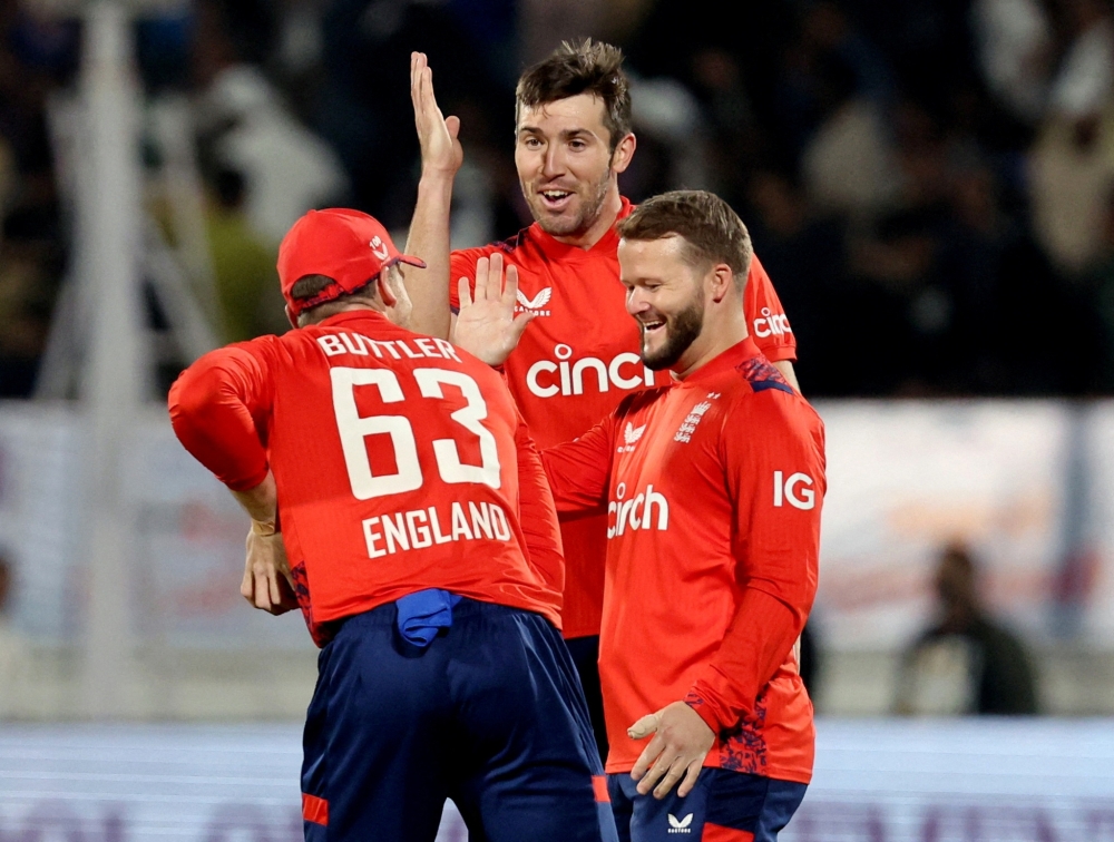 Cricket - Third T20 International - India v England - Saurashtra Cricket Association Stadium, Rajkot, India - January 28, 2025 England's Jamie Overton and Jos Buttler celebrate after taking the wicket of India's Hardik Pandya with Ben Duckett REUTERS/Amit Dave     TPX IMAGES OF THE DAY
