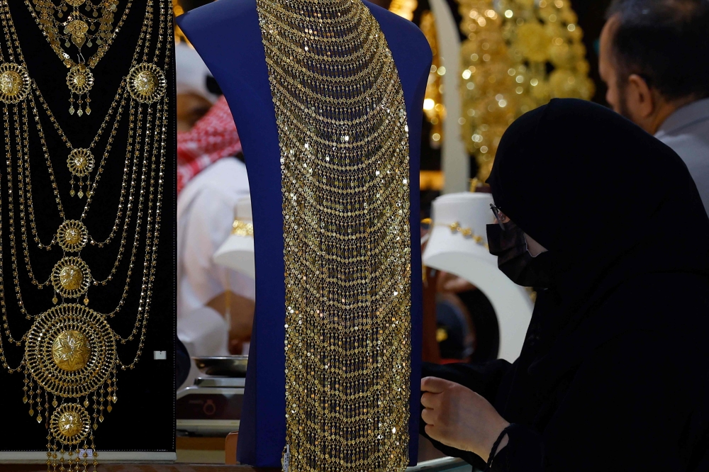 A woman checks gold ornaments 