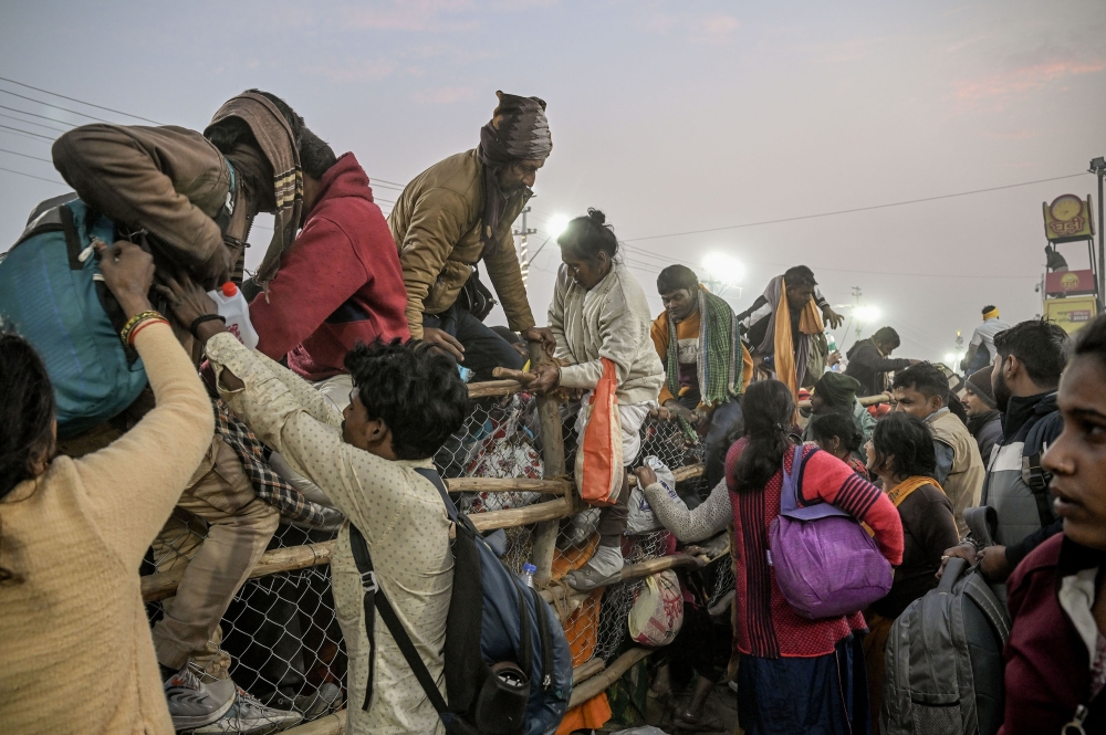 People cross the barriers near the area where a stampede took place at the Kumbh Mela in Prayagraj, India on Wednesday, Jan. 29, 2025. (Atul Loke/The New York Times)
