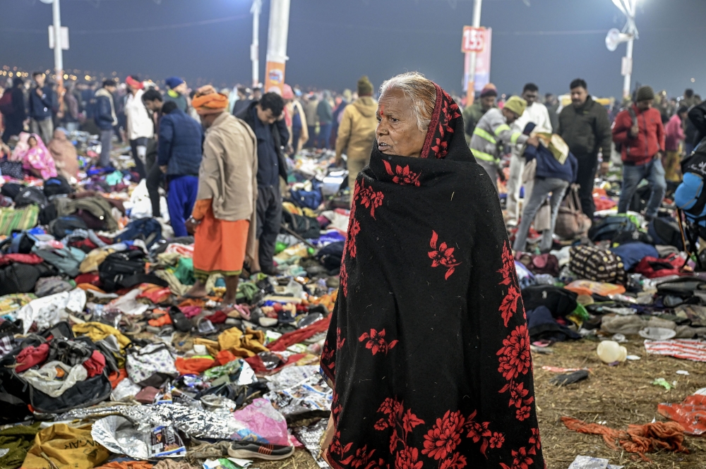 A woman stands among debris after a stampede at the Kumbh Mela in Prayagraj, India on Wednesday, Jan. 29, 2025. (Atul Loke/The New York Times)