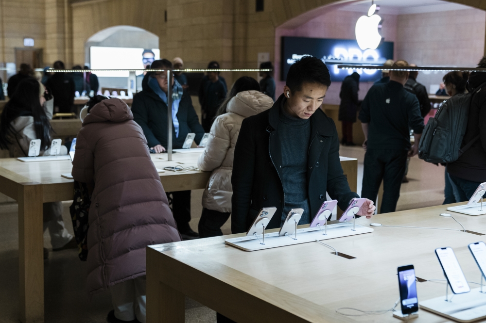 A visitor examines a new iPhone at the Apple Store in Grand Central Terminal in Manhattan, Jan. 24, 2025. (Juan Arredondo/The New York Times)