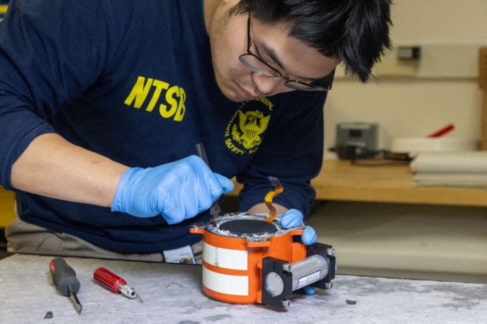 An NTSB investigator works on the black box of American Eagle flight 5342, which was involved in a collision with a Black Hawk helicopter, 
