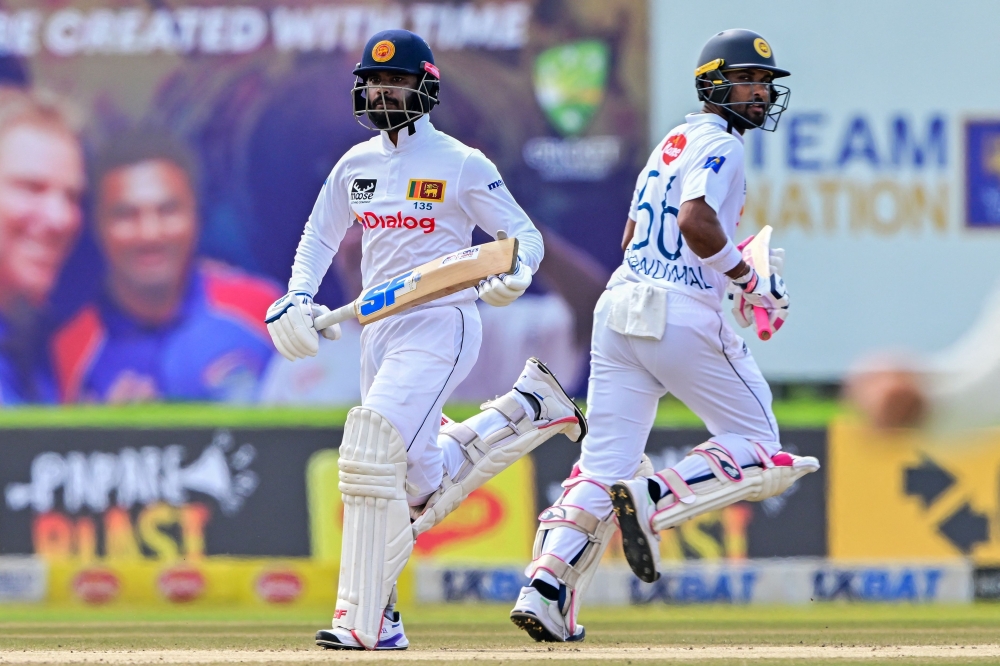 Sri Lanka's Dinesh Chandimal (R) and captain Dhananjaya de Silva run between the wickets 