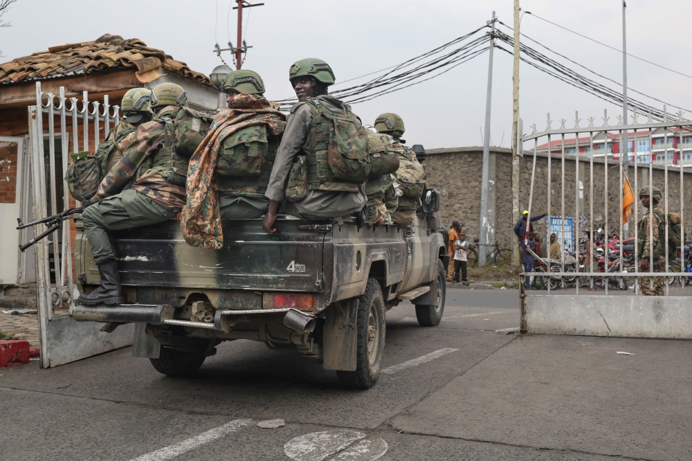Members of the M23 armed group arrive in a pickup truck at the compound where residents gather for a protest against the Congolese government in Goma
