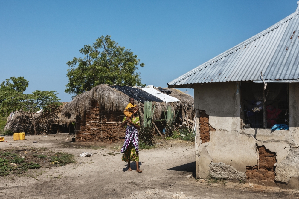 Zainath Juma, a former Husk customer, and her son outside their home in Matipwili, Tanzania, in January 2025. (Malin Fezehai/The New York Times)