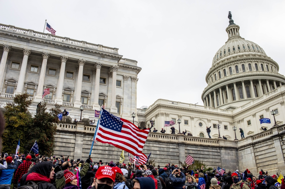 Pro-Trump rioters climb the Capitol walls in Washington, Jan. 6, 2021. (Jason Andrew/The New York Times)