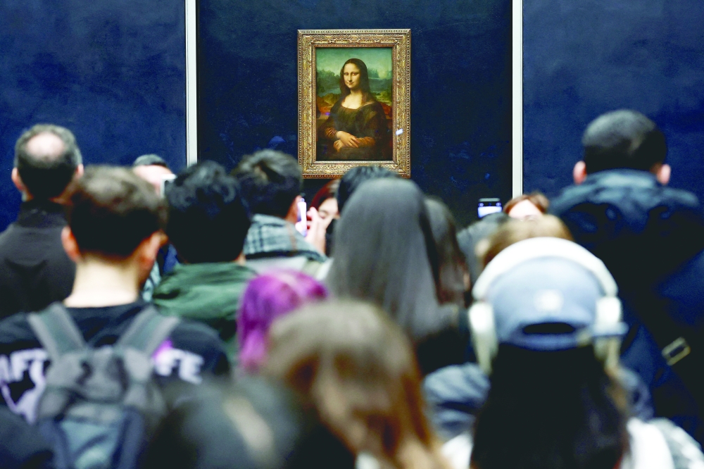 Visitors look at the painting "Mona Lisa" (La Joconde) by Leonardo da Vinci at the Louvre Museum in Paris, France, January 29, 2025. 
