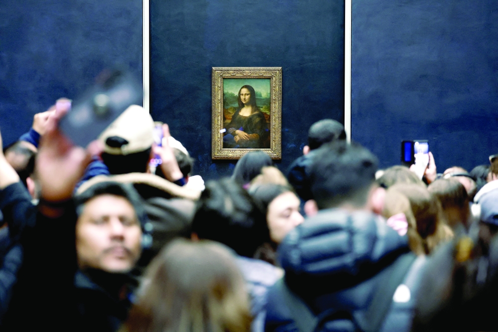 Visitors take pictures of the painting "Mona Lisa" (La Joconde) by Leonardo da Vinci at the Louvre Museum in Paris, France, January 29, 2025. 