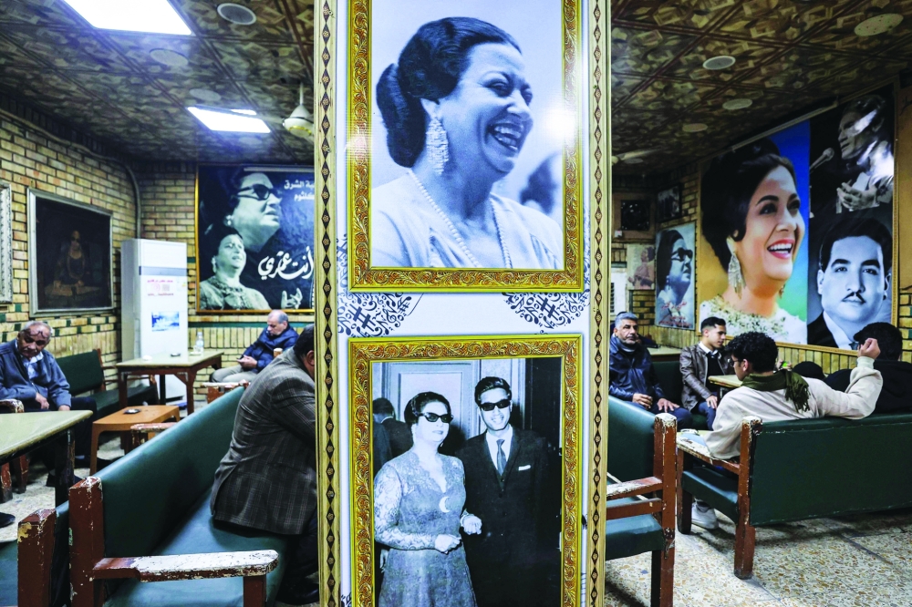 People sit at the Umm Kulthum cafe, which opened in 1970 and is named after the late Egyptian Arabic music icon Umm Kulthum, along al-Rashid Street in the old city of Baghdad on January 27, 2025.  (Photo by AHMAD AL-RUBAYE / AFP)