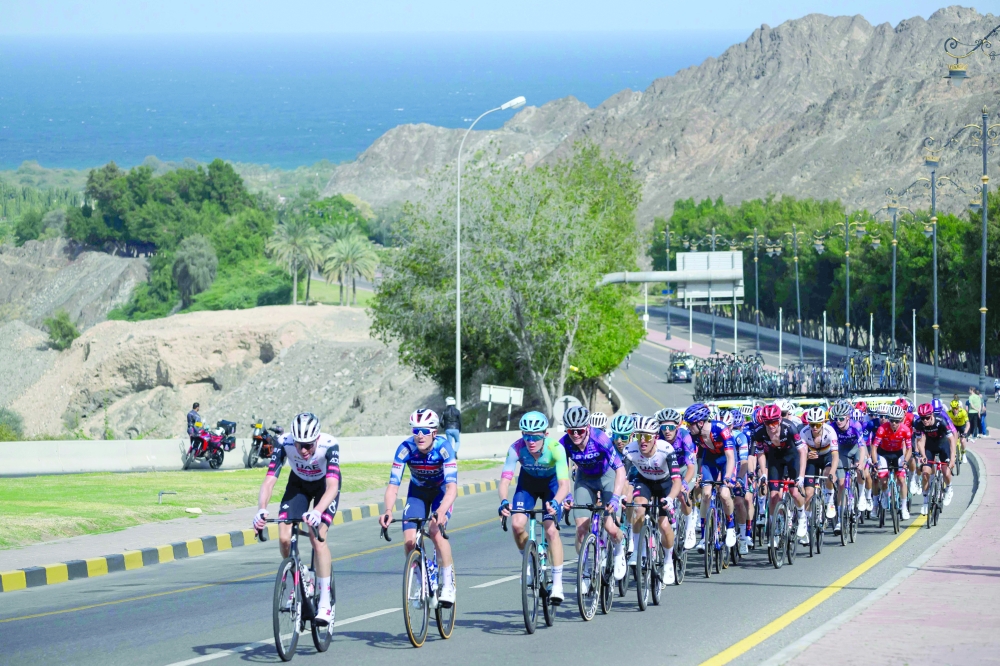 The pack rides during the Muscat Classic cycling race, in Muscat on February 7, 2025. (Photo by Loic VENANCE / AFP)
