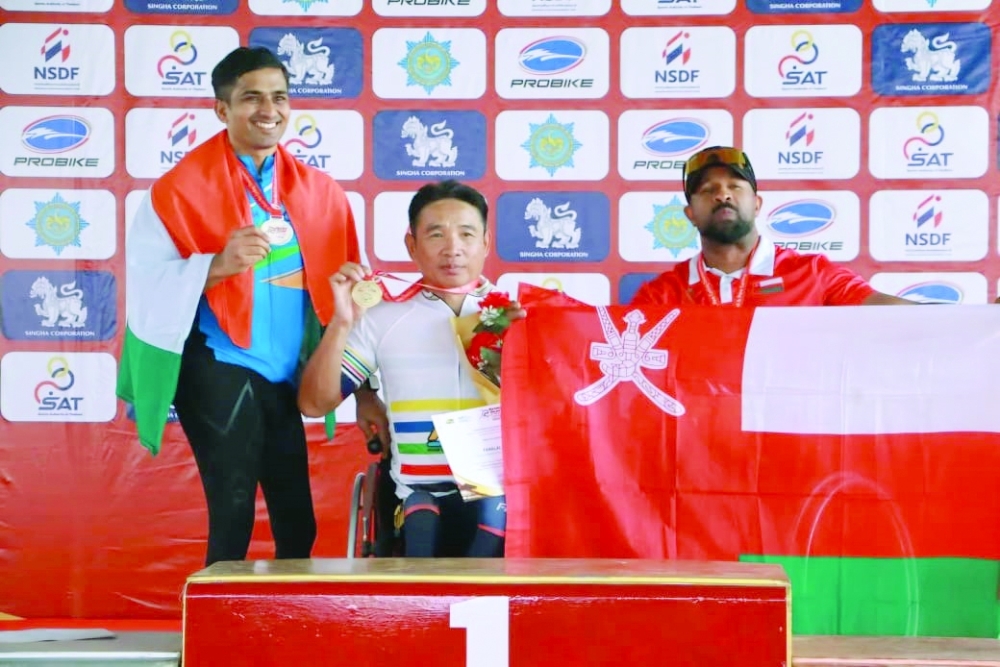 Sami al Salmi holds Oman flag on the podium.