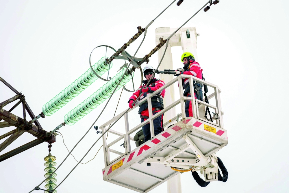 A photo shows technicians working to disconnect the major power line between Latvia and Russia in Vilaka, Latvia, near the Russian border. — AFP