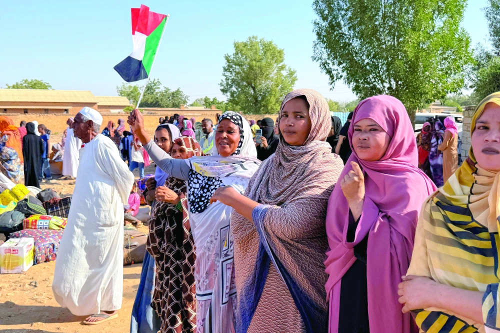 A woman holds the Sudanese flag
