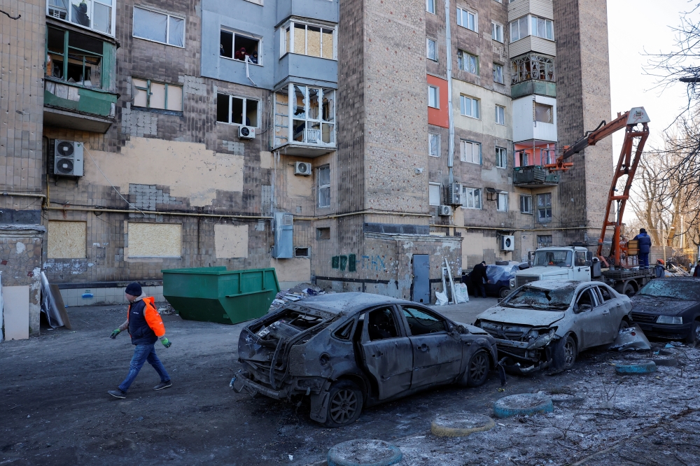 People carry out repair works in the courtyard of a damaged multi-storey residential building following recent shelling, in Makiivka, a Russian controlled region of Ukraine. — Reuters 