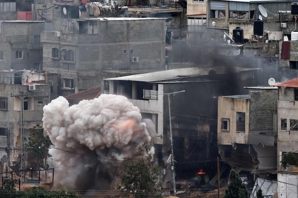Smoke billows after an explosion during an Israeli raid in the Nur Shams refugee camp near Tulkarem in the West Bank. — AFP 