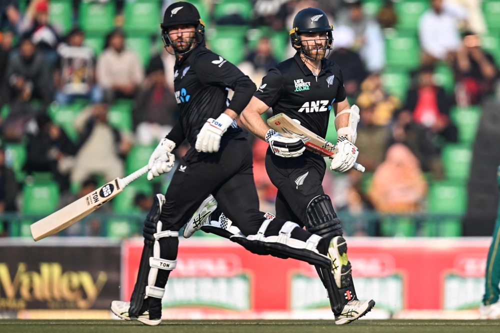 New Zealand's Devon Conway with teammate Kane Williamson run between the wickets during the Tri-Nation series second one-day international (ODI) cricket match between New Zealand and South Africa at the Gaddafi Stadium in Lahore on February 10, 2025.  (Photo by Farooq NAEEM / AFP)

