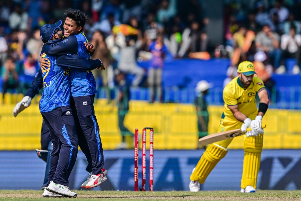 TOPSHOT - Sri Lanka's Dunith Wellalage (C) celebrates with teammates after taking the wicket of Australia's Glenn Maxwell (R) during the second and last one-day international (ODI) cricket match between Sri Lanka and Australia at the R. Premadasa International Cricket Stadium in Colombo on February 14, 2025. (Photo by Ishara S. KODIKARA / AFP)


