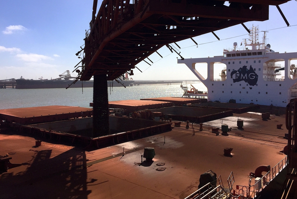 The logo of Australia's Fortescue Metals Group can be seen on a bulk carrier as it is loaded with iron ore at the coastal town of Port Hedland in Western Australia. - File Photo