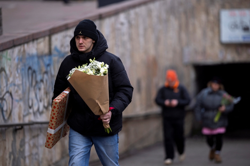 A man carries flowers, amid Russia's attack on Ukraine, on Valentine's Day in Kyiv. - Reuters
