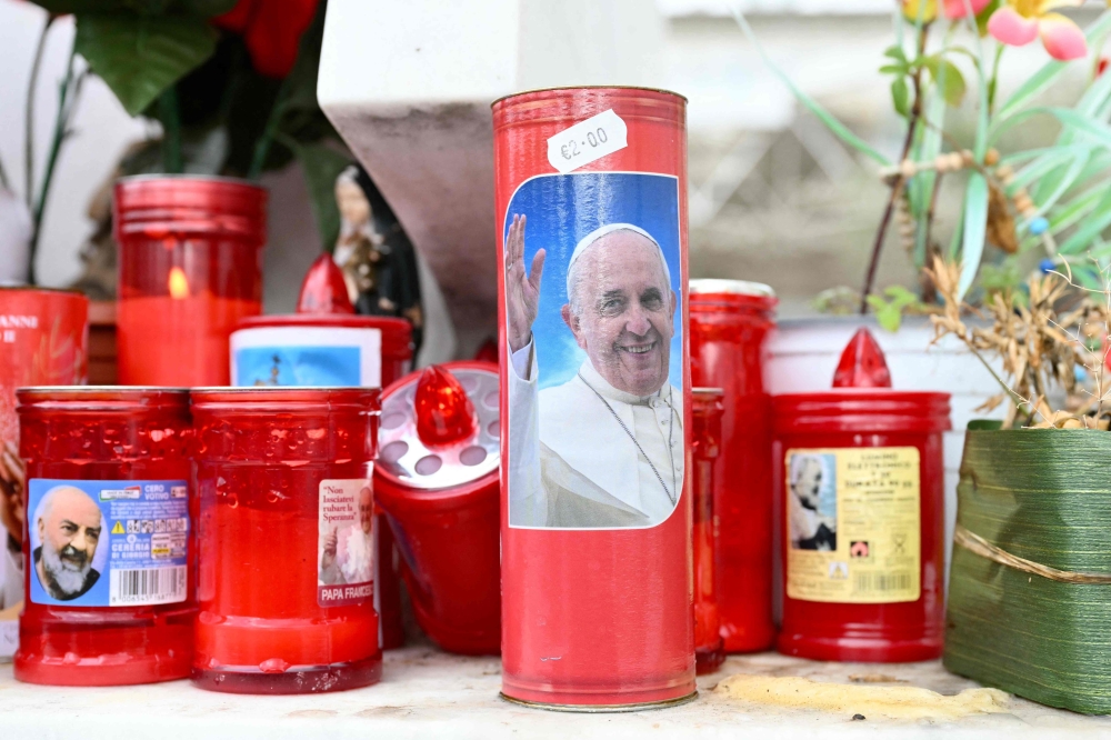 A candle with a picture of Pope Francis