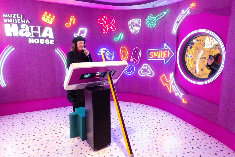 Zorica Bucic, a visitor from Split, sings in karaoke room as she visits the HaHaHouse museum of laughter in central Zagreb, on January 21, 2025. The 450-square-metre (4,844-square-feet) museum, which opened in January, offers eight interactive zones and has also an educational part featuring the history of humour from ancient to modern times and via different formats -- theatre, film or Internet.  (Photo by Damir SENCAR / AFP)


