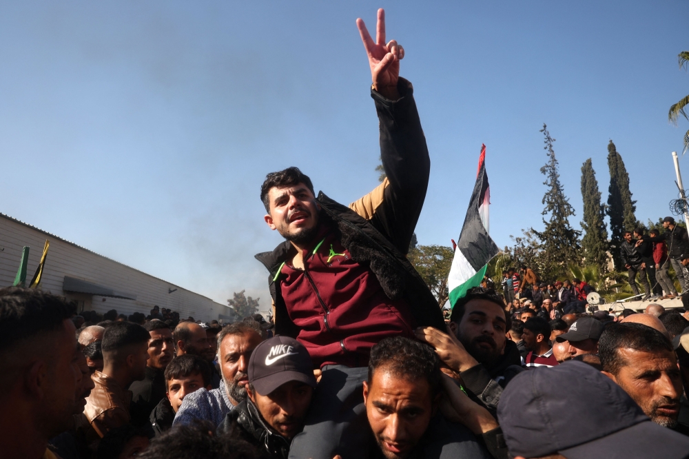 A former Palestinian prisoner, released as part of the sixth hostage-prisoner exchange, flashes the V for victory sign as he is welcomed by friends and relatives upon arriving at the European Hospital in Khan Yunis on Saturday. - AFP