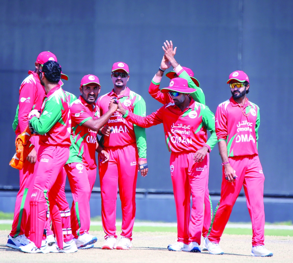 Oman players celebrate after a wicket.