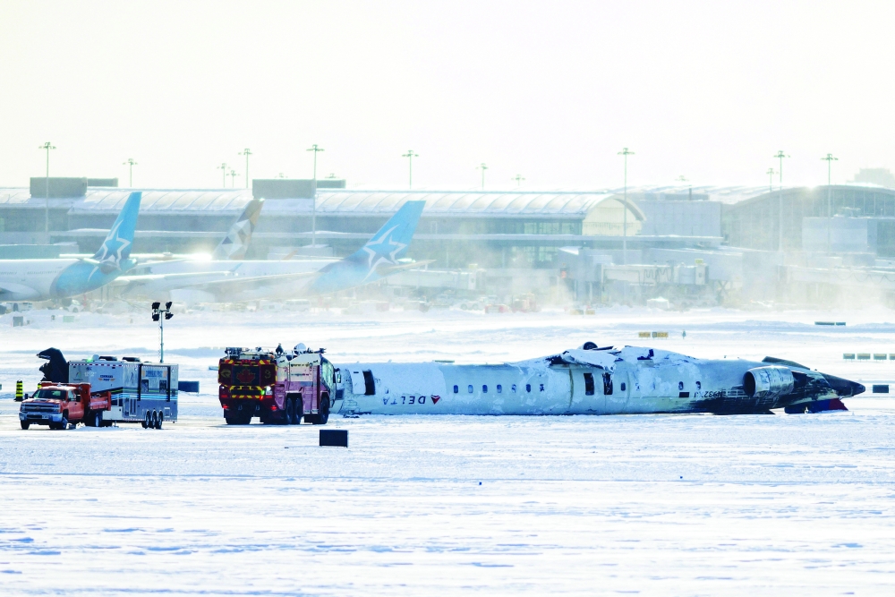 The wreckage of a Delta Air Lines-operated CRJ900 aircraft lays on the runway at Toronto Pearson International Airport. — Reuters