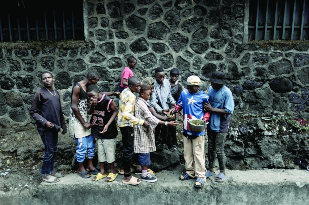 A group of street children share food given to them by a local resident, in Goma. — AFP 