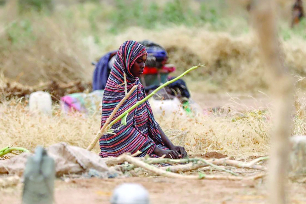 A displaced Sudanese woman kneels to pray at a camp near the town of Tawila in North Darfur. — AFP