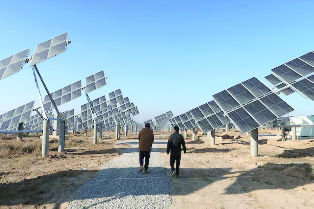 Workers walk at a solar power station in Tongchuan, Shaanxi province, China. — Reuters
