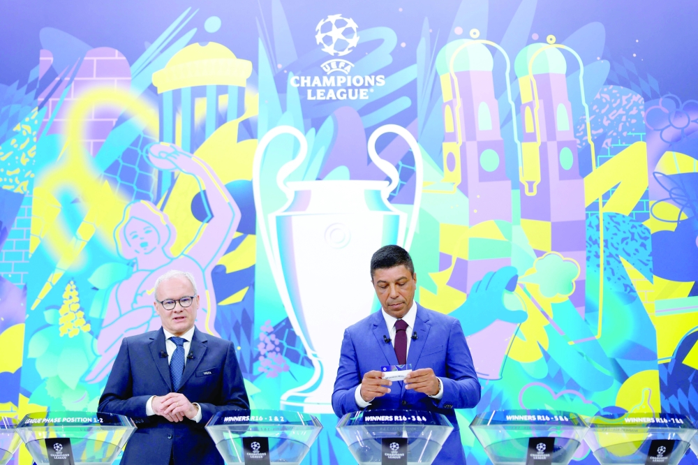 Brazilian former football international Giovane Elber (R) a team slip flanked by UEFA Deputy Secretary General Giorgio Marchetti (L) during the draw for the round of 16 of the 2024-2025 UEFA Champions League football tournament at the House of European Football in Nyon, on February 21, 2025. (Photo by Valentin Flauraud / AFP)