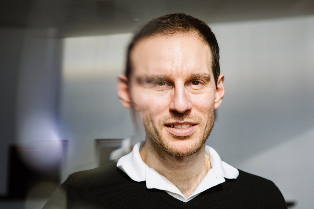 Alessio Figalli is seen through a refraction of eyeglasses on the campus of the Institute for Advanced Study in Princeton. Figalli is a mathematician at ETH Zurich and a current member at the institute. 