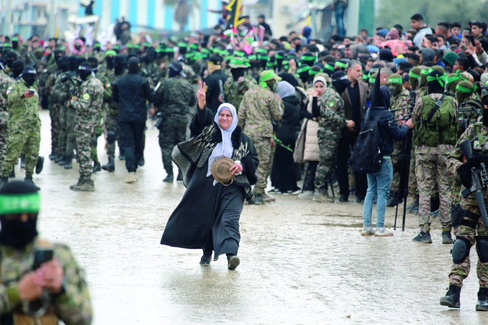 A Palestinian woman walks among Hamas fighters in Nuseirat in the central Gaza Strip. — AFP