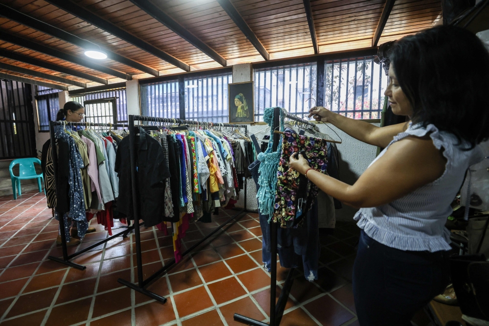 A teacher browses clothes inside a second-hand run by the Venezuelan Teachers' Federation (FVM) in Caracas