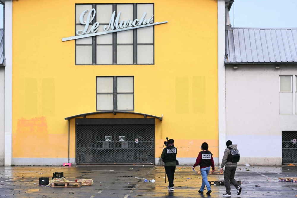 French forensic police work to collect evidence at the site, in Mulhouse, eastern France. — AFP
