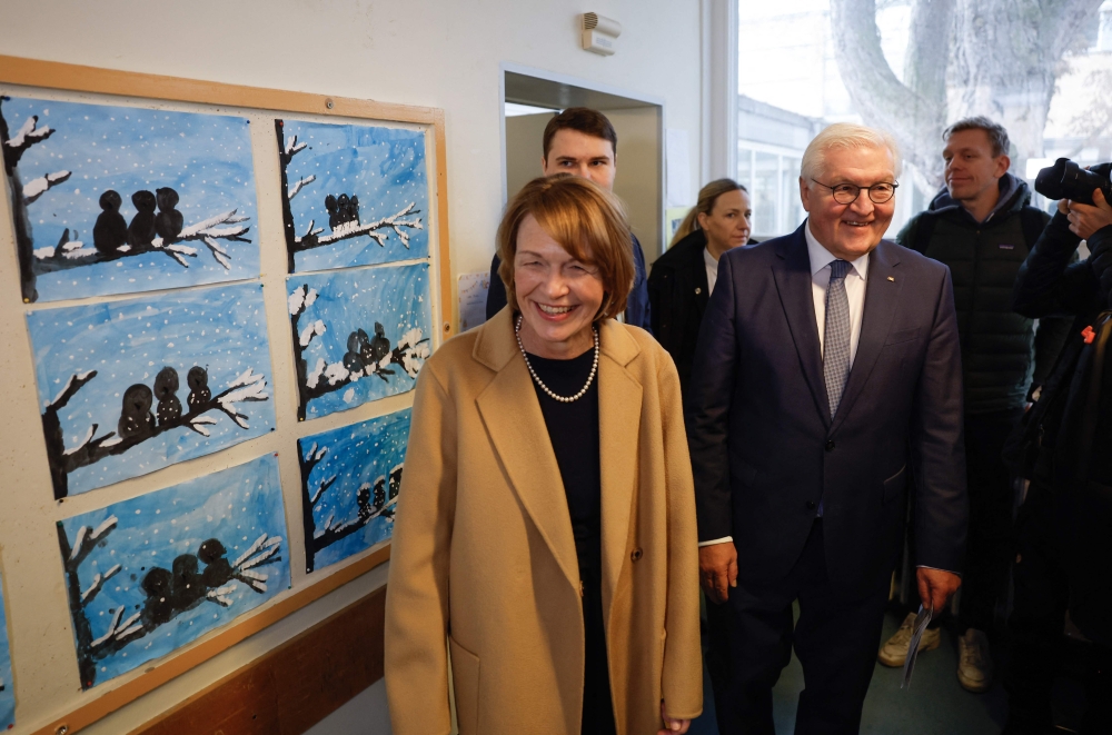 German President Frank-Walter Steinmeier and his wife Elke Buedenbender enter the voting office, in Berlin. — AFP 