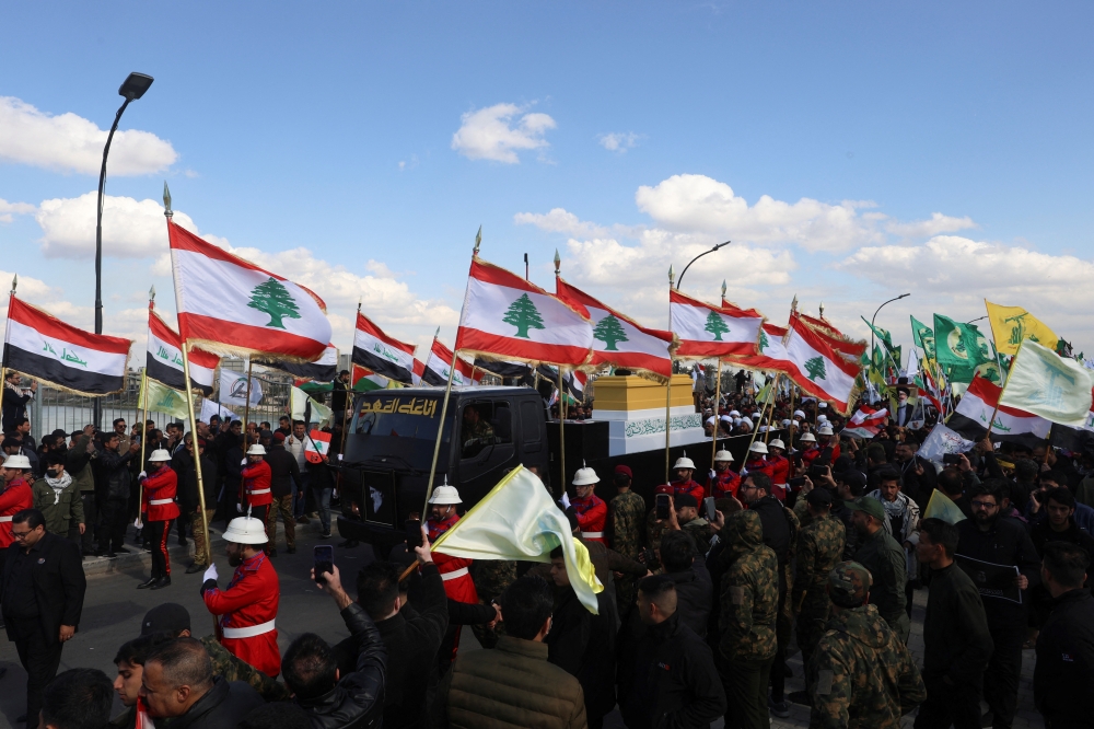 People hold Lebanese, Iraqi and Hezbollah flags 