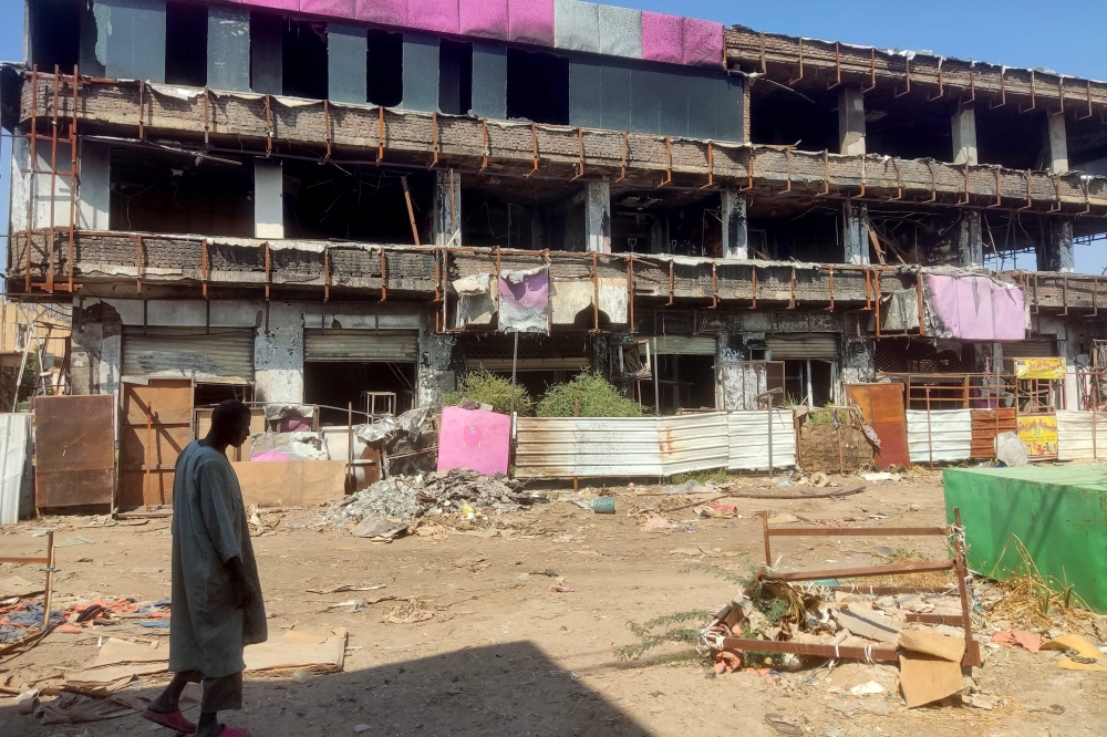 A man walks past a damaged building in Wad Madani, which was retaken by the Sudanese army a month earlier, in Sudan's Al Jazira state.— AFP 

