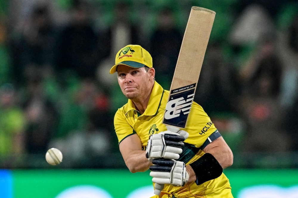 Australia's captain Steve Smith watches the ball after playing a shot during the ICC Champions Trophy one-day international (ODI) cricket match between Australia and Afghanistan at the Gaddafi Stadium in Lahore on February 28, 2025.  (Photo by Aamir QURESHI / AFP)