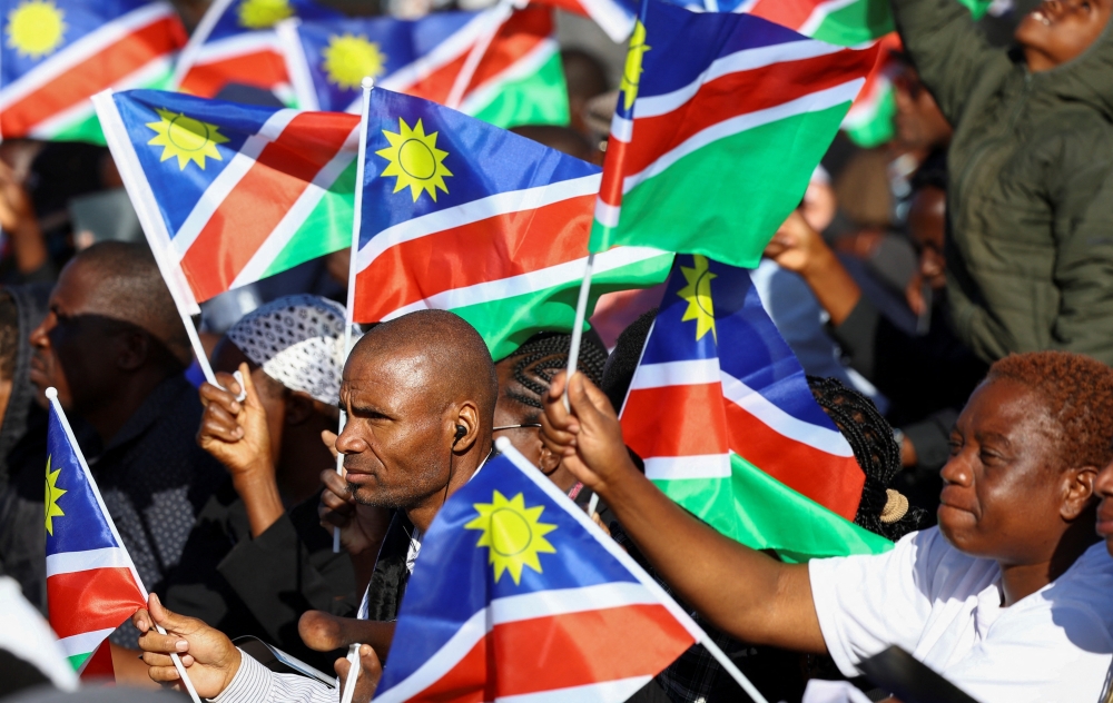 Mourners hold Namibian flags during the burial of Sam Nujoma, who became Namibia's first democratically elected president, at Namibia's Heroes' Acre, near the capital Windhoek, Namibia, March 1, 2025. REUTERS/Siphiwe Sibeko
