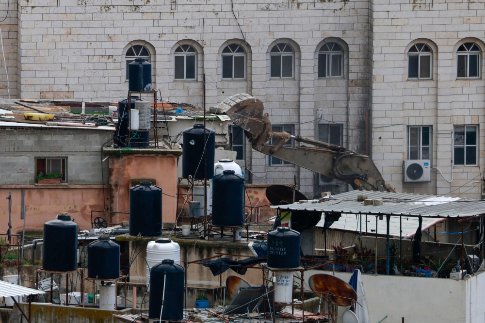 An Israeli military bulldozer demolishes a home at the Nur Shams camp for Palestinian refugees east of Tulkarem in the occupied West Bank on Saturday.  AFP