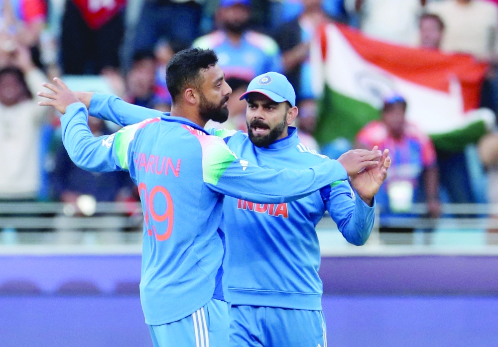 Chakravarthy celebrates with Virat Kohli. — Reuters