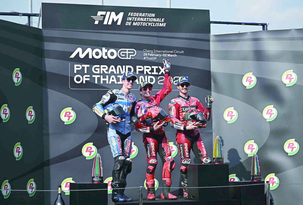 Marquez (C), second-placed Alex (L) and third-placed Francesco (R). — Reuters